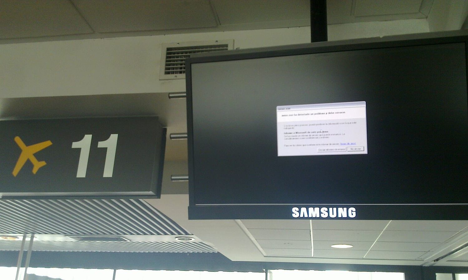 Bildschirm an einem Flughafen-Gate zeigt ein Windows-Fehlerfenster statt der Fluginformation