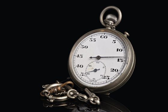 Alte mechanische Stoppuhr mit Kette vor schwarzem Hintergrund